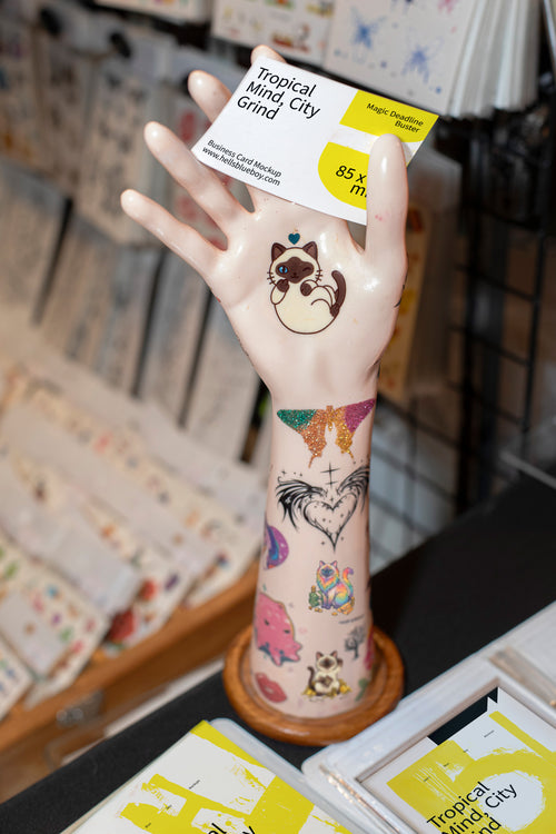 Business card mockup with a mannequin display hand and market stall background