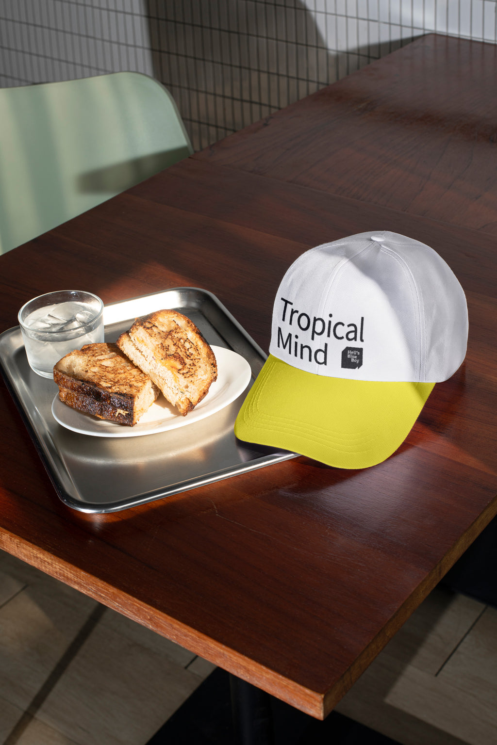 Baseball cap mockup placed on a café table with sandwich.