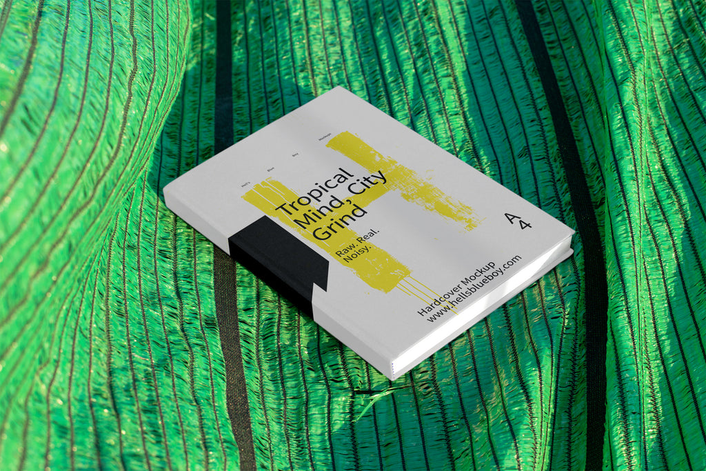 Hardcover book cover mockup set against a green mesh plastic background used for outdoor shading in Thailand. Ideal for editorial and print design.