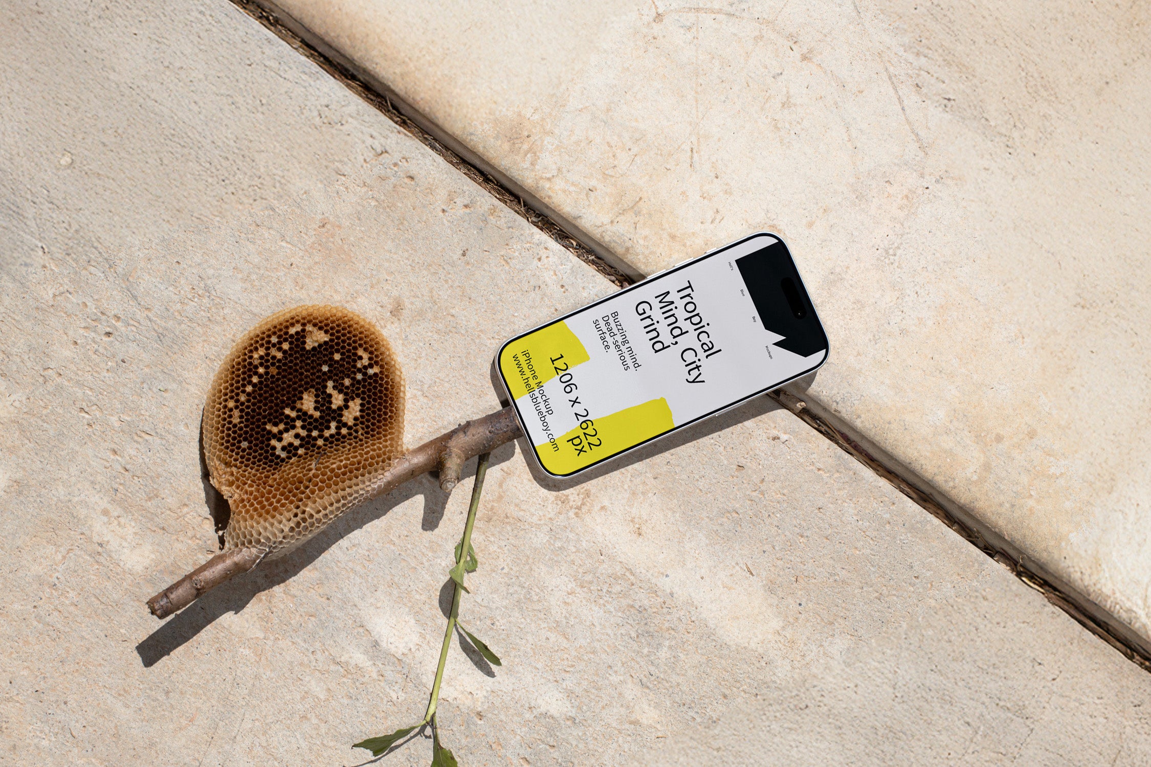 iPhone mockup lying on concrete plates with a wooden stick and honeycomb. Ideal for showcasing app screens, UI design, and mobile branding.