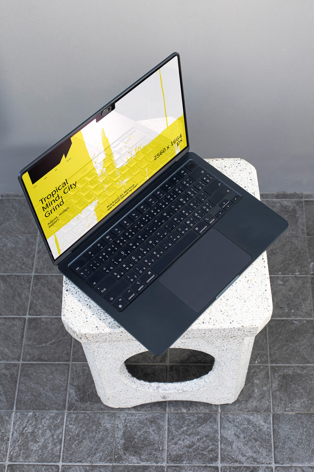 MacBook mockup placed on a concrete bench.