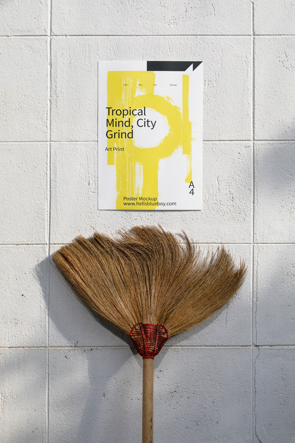 Poster mockup displayed on a white brick wall with a moustache-shaped broom below.