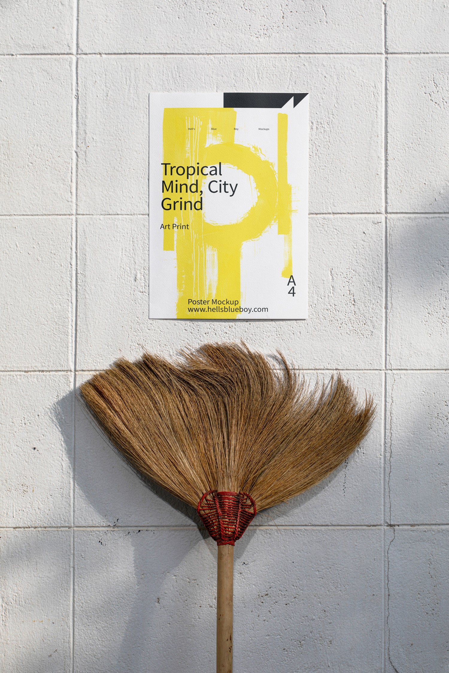 Poster mockup displayed on a white brick wall with a moustache-shaped broom below.