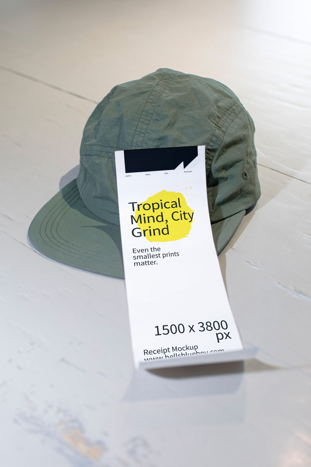 Cashier receipt mockup placed on a white wooden table with a green cap.