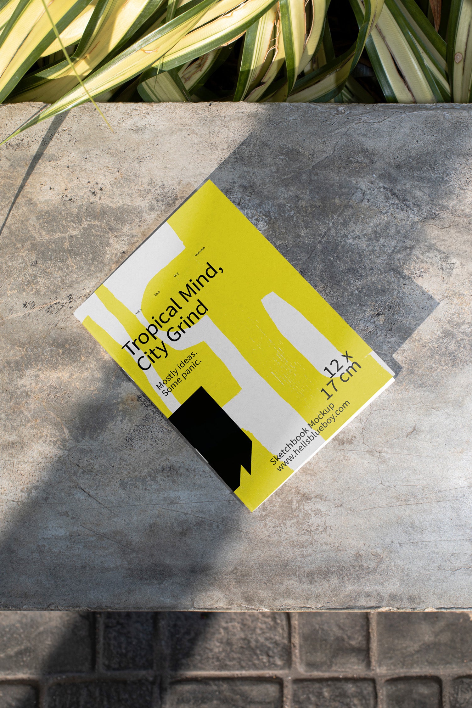 High-resolution sketchbook mockup placed on a concrete bench.